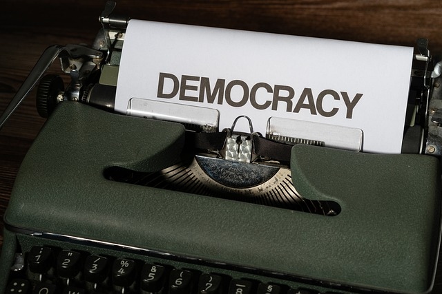 Schreibmaschine mit Blatt, auf dem steht "Democracy"