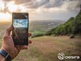 Aufnahme eines Handys, das eine Landschaft fotografiert