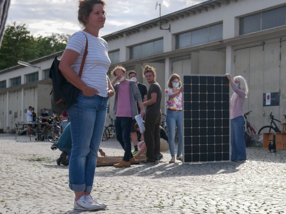 ITAS-Mitarbeiter präsentiert ein Solarpanel vor Bürger*innen für das Projekt Dein BalkonNetz.
